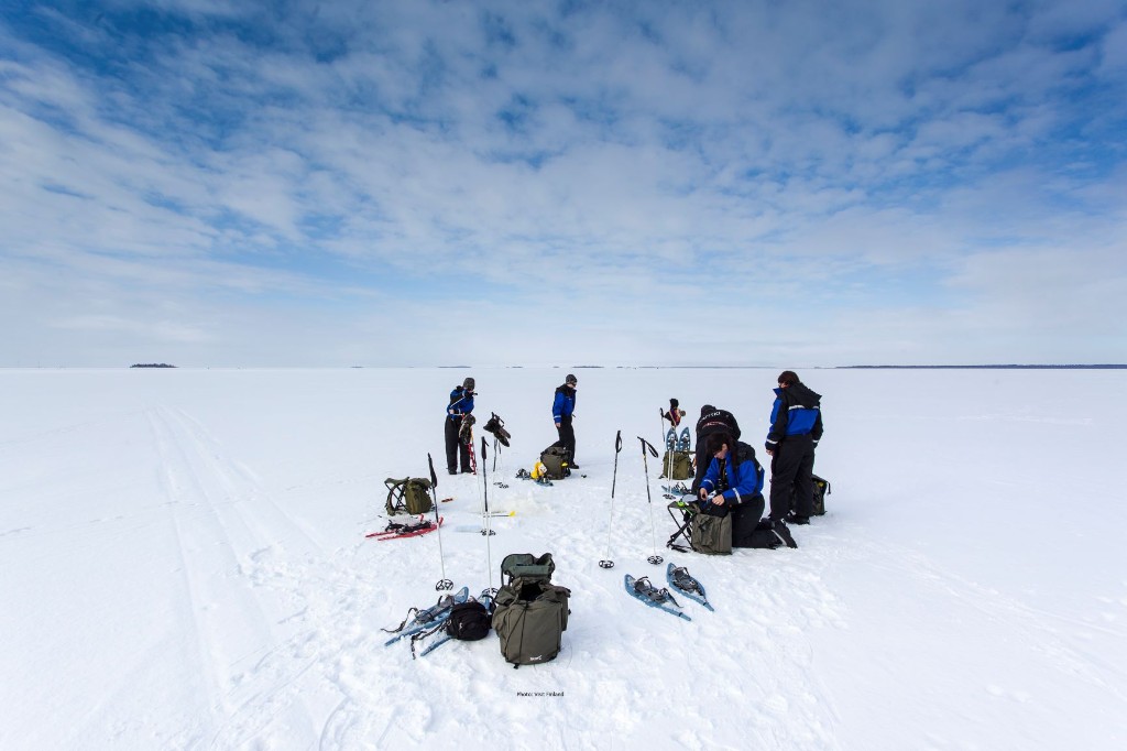 Group preparing gear on a frozen Arctic lake