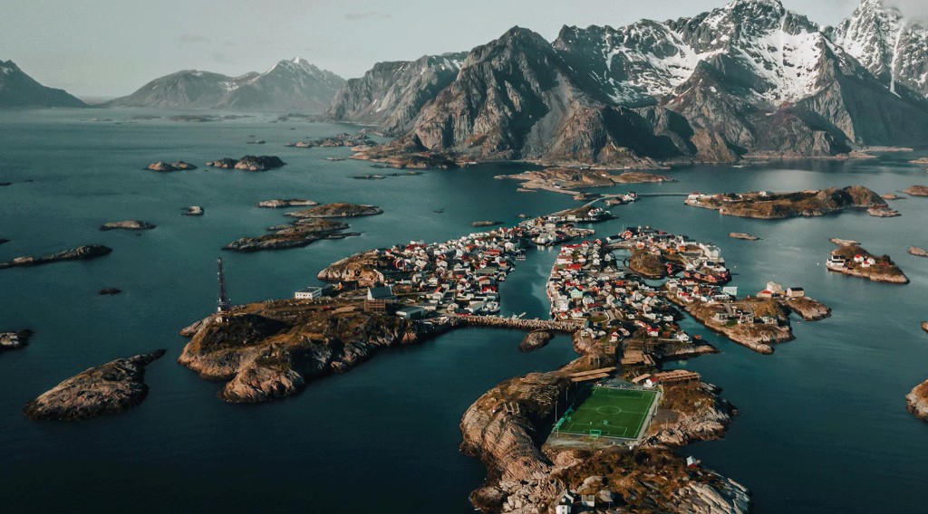 Aerial view of Henningsvær’s islands, rorbuer, and football pitch by the Norwegian Sea