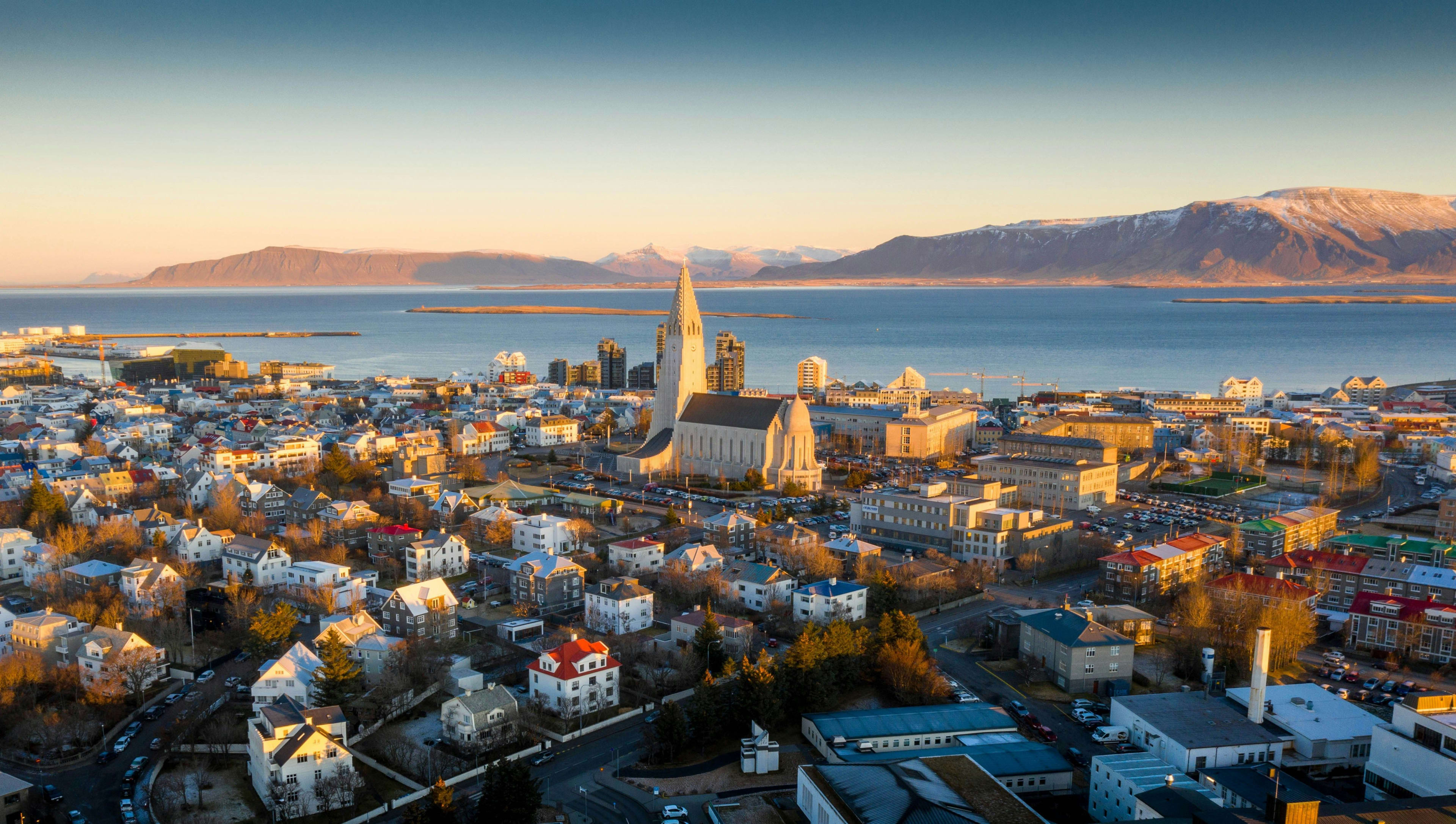 Reykjavík rooftops and harbour bathed in low sunset light