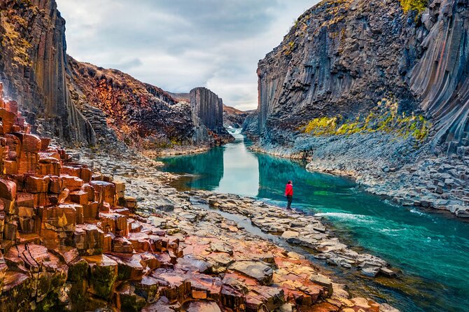 Basalt columns lining the turquoise river of Stuðlagil canyon