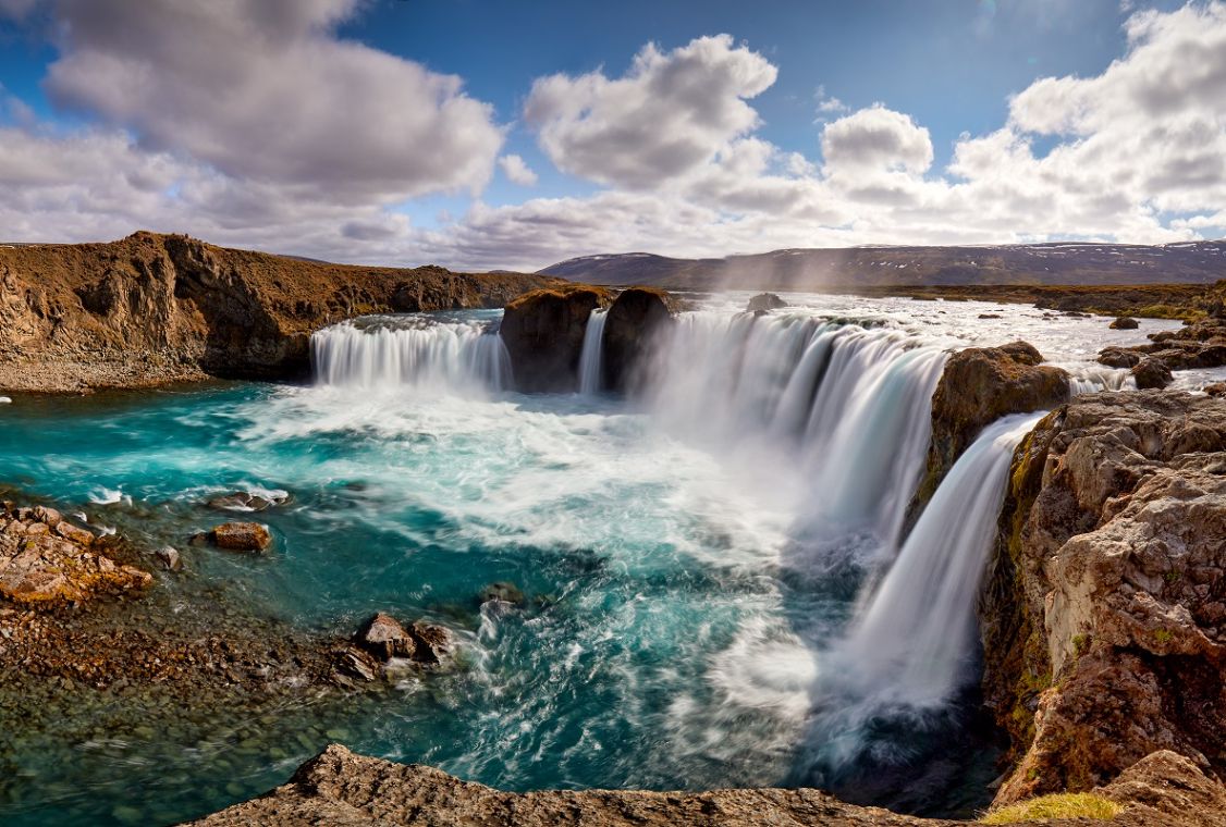 Goðafoss waterfall curving over dark volcanic rock