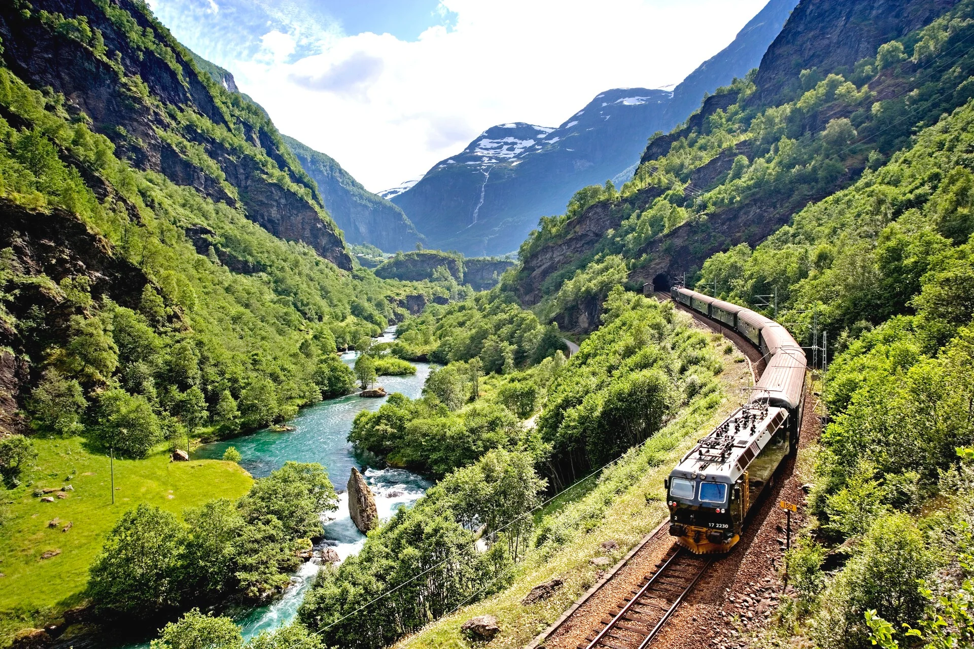 The Flåm Railway descending through a steep Norwegian valley